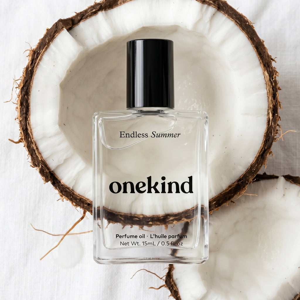 onekind perfume oil bottle on a white background with a coconut half