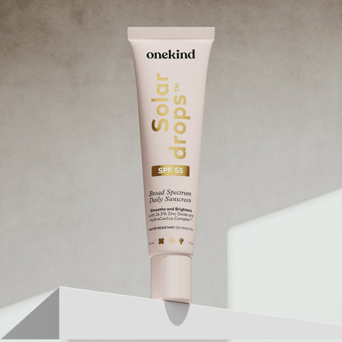 OneKind Solar Drops sunscreen tube on a neutral background
